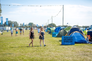 Victorious Festival campsite at Farlington Fields offsite campsite with several tents and a sign asking campers to keep the campsite tidy